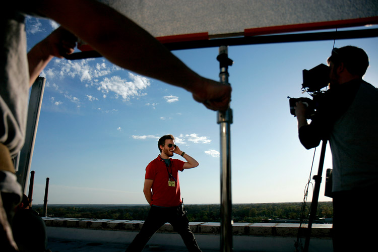 Sean Gartner, center, stands in for an actor as Keith Hueffmeier, right, checks focus on the camera, and Adam Huber sets up a light reflector on the roof of the Tiger Hotel in Columbia, MO as part of the film <em>Venganza Azteca</em>. The feature film was made by both students of the University of Missouri and by professionals. The film's plot features a Mexican wrestler doing battle against an Aztec chief's severed head.